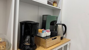 A kitchen area with a coffee maker, a kettle, and a jar of jam on the shelf. - Caltur B&B (Palermo)