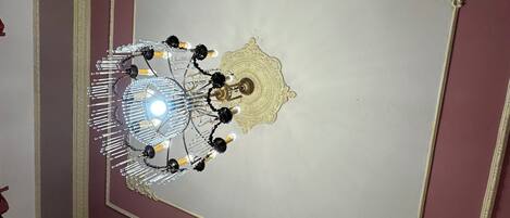 A ceiling with a decorative light fixture and a central medallion design.