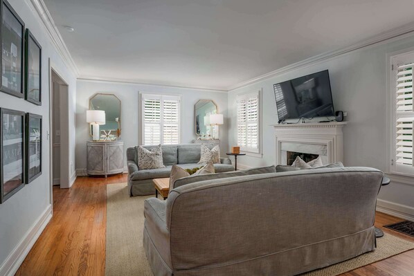 A living room with a grey sofa, a television, and a fireplace.