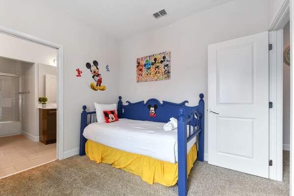 Children's bedroom with a blue Mickey Mouse-themed bed and colorful wall art.