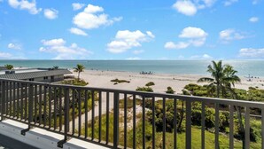 A beachfront view from a balcony with a railing, a sandy beach, and the ocean. - Beautiful panoramic views of the Gulf, 2 bedroom w/sleeping den, 2 bath condo (Sanibel)