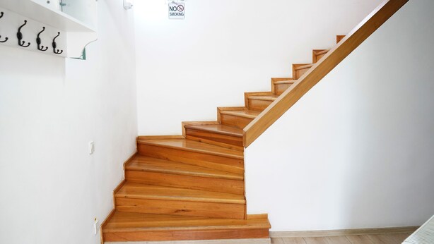 A staircase with wooden steps and a handrail, leading to a landing with a 'No Smoking' sign. - HOTEL GREEN GARDEN (Bucharest)