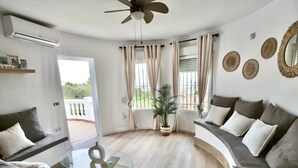 A modern living room with a glass coffee table, a sofa, and a curved seating area. - Villa Familia located on the Montgo with stunning views over the bay of Denia. (Dénia)