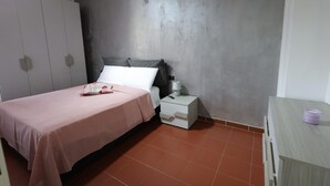 Une chambre à coucher avec un lit, une table de chevet et une armoire.