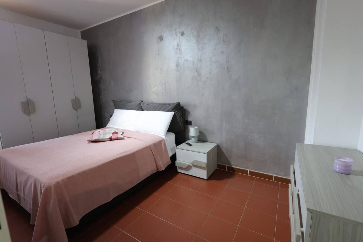Une chambre à coucher avec un lit, une table de chevet et une armoire.