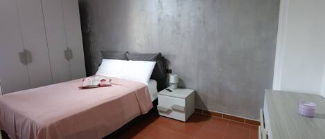 A bedroom with a bed, bedside table, and a wardrobe.