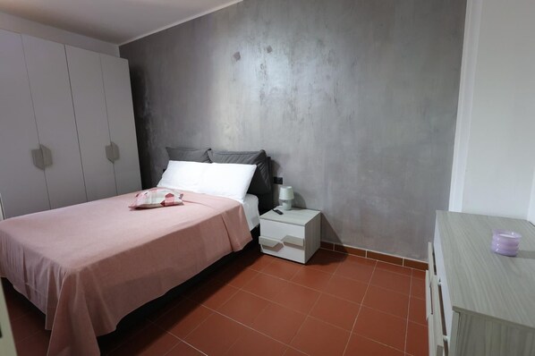 A bedroom with a bed, bedside table, and a wardrobe.