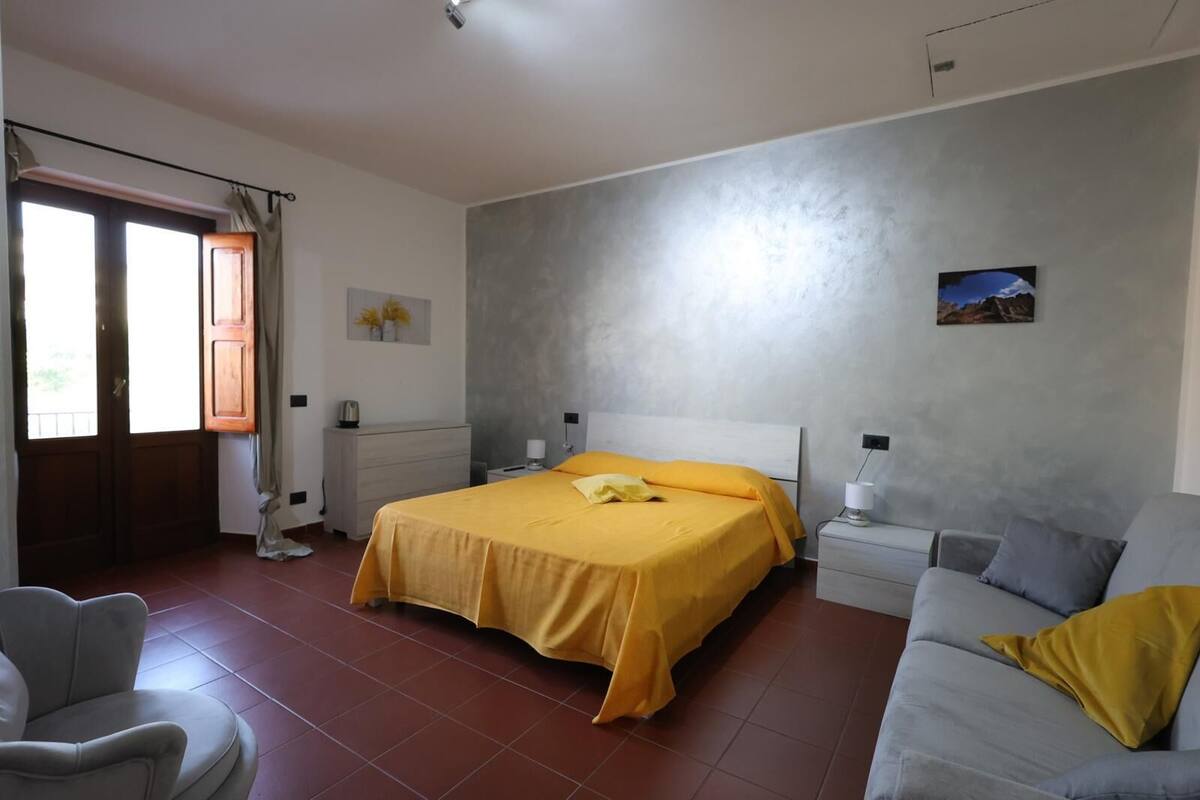 Une chambre à coucher avec un lit, une table de chevet, une chaise et un canapé.