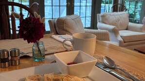 Une table à manger avec une assiette de nourriture, une tasse et un bol de baies.
