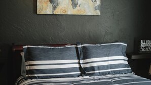A bed with striped bedding, a world map on the wall, and a motivational sign. - Near Razorback Stadium & Attractions, Firepit (Springdale)