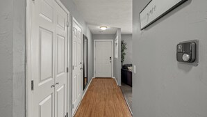 A hallway with white doors, a thermostat, and a sign that reads "inhaler grace". - Near Razorback Stadium & Attractions, Firepit (Springdale)