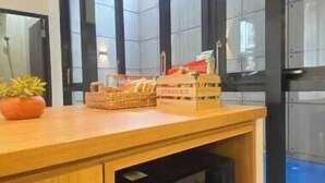 Uma cozinha com bancada de madeira, micro-ondas e uma cesta de petiscos.