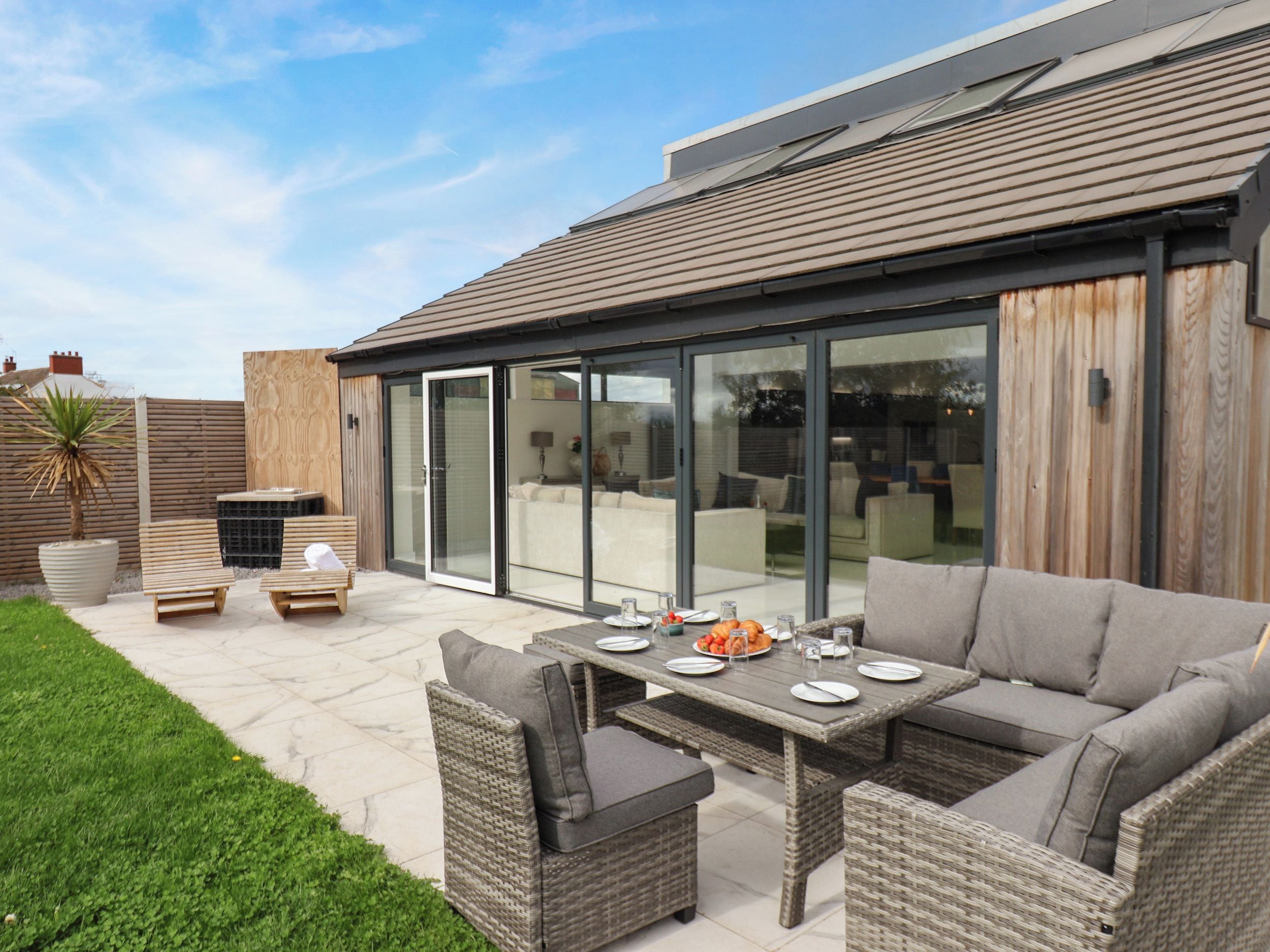 A patio area with a dining table, chairs, and a sofa.