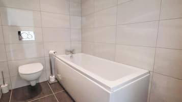 A bathroom with a toilet, a bidet, and a bathtub.