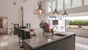 A modern kitchen with a granite countertop, stainless steel appliances, and pendant lighting. - Meadow View (Beverley)