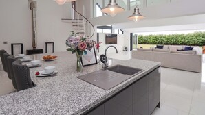 A modern kitchen with granite countertops, a built-in sink, and pendant lighting. - Meadow View (Beverley)