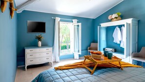 A bedroom with a bed, a dresser, a TV, a wardrobe, and a window with curtains. - La Mansarda Chic by TuscanyWeGo (Prato)