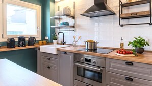 A modern kitchen with a built-in oven, a sink, and a stove. There are various kitchen utensils and appliances on the countertops. - La Mansarda Chic by TuscanyWeGo (Prato)