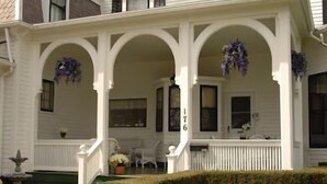 A white two-story house with a covered porch, a number '176' on the wall, and a small garden area with a fountain. - The Alfred Morris Gifford House has been lovingly renovated to anticipate the every need of travelers to the Finger Lakes area.  Located in the heart of the Historic District, the Inn is a short walk to restaurants, historical sites, shops, as well a (Canandaigua)