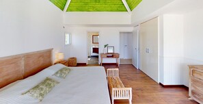 Une chambre avec un grand lit, un bureau et une armoire.