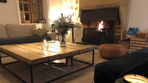 A cozy living room with a fireplace, a wooden coffee table, a sofa, and a magazine on the floor. - La Thibaude - Vigeronne house near Lyon (Charly)