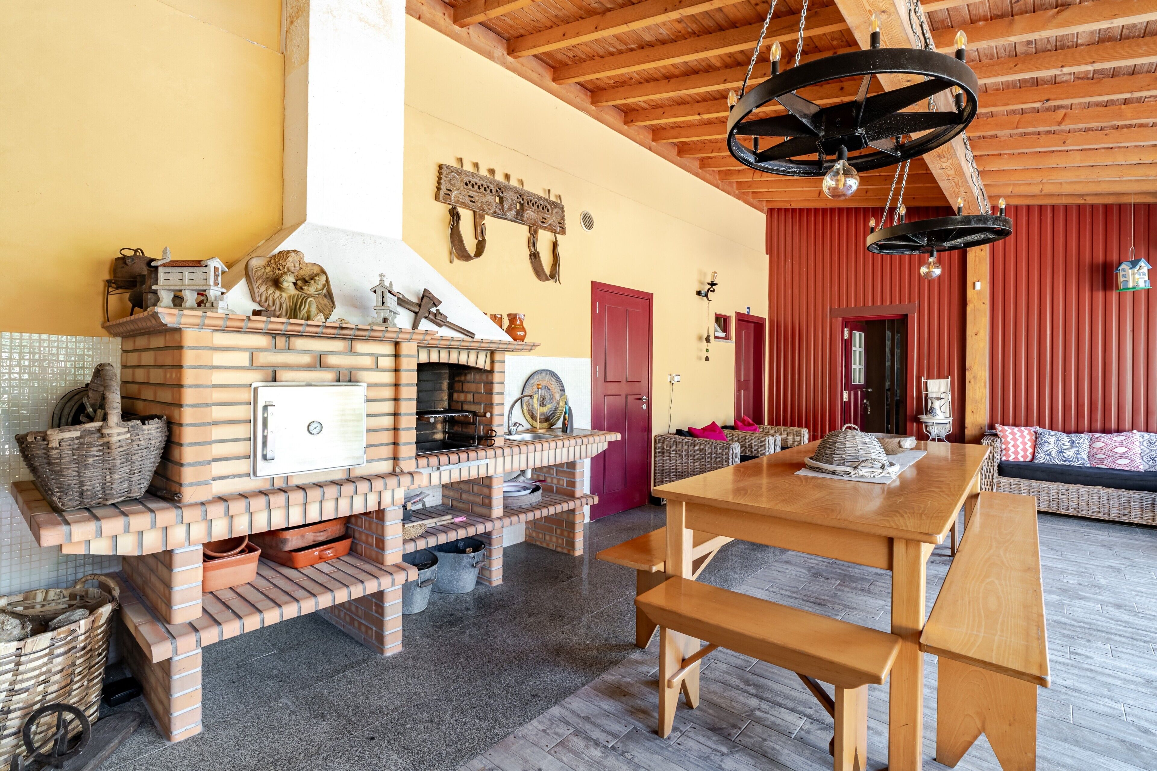 Una chimenea de ladrillo con una chimada, una mesa de comedor de madera y una pared roja.