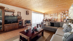 Ein Wohnzimmer mit Holzboden, einem Fernseher, einer Couch und einem Couchtisch.