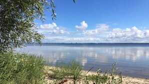 Tyyni järvi, jonka rannalla on hiekkaranta ja vähäistä kasvillisuutta.
