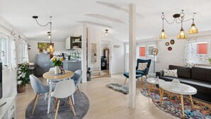 Eine moderne Wohnung mit Essbereich, Küche, Wohnzimmer und einem kleinen Balkon.