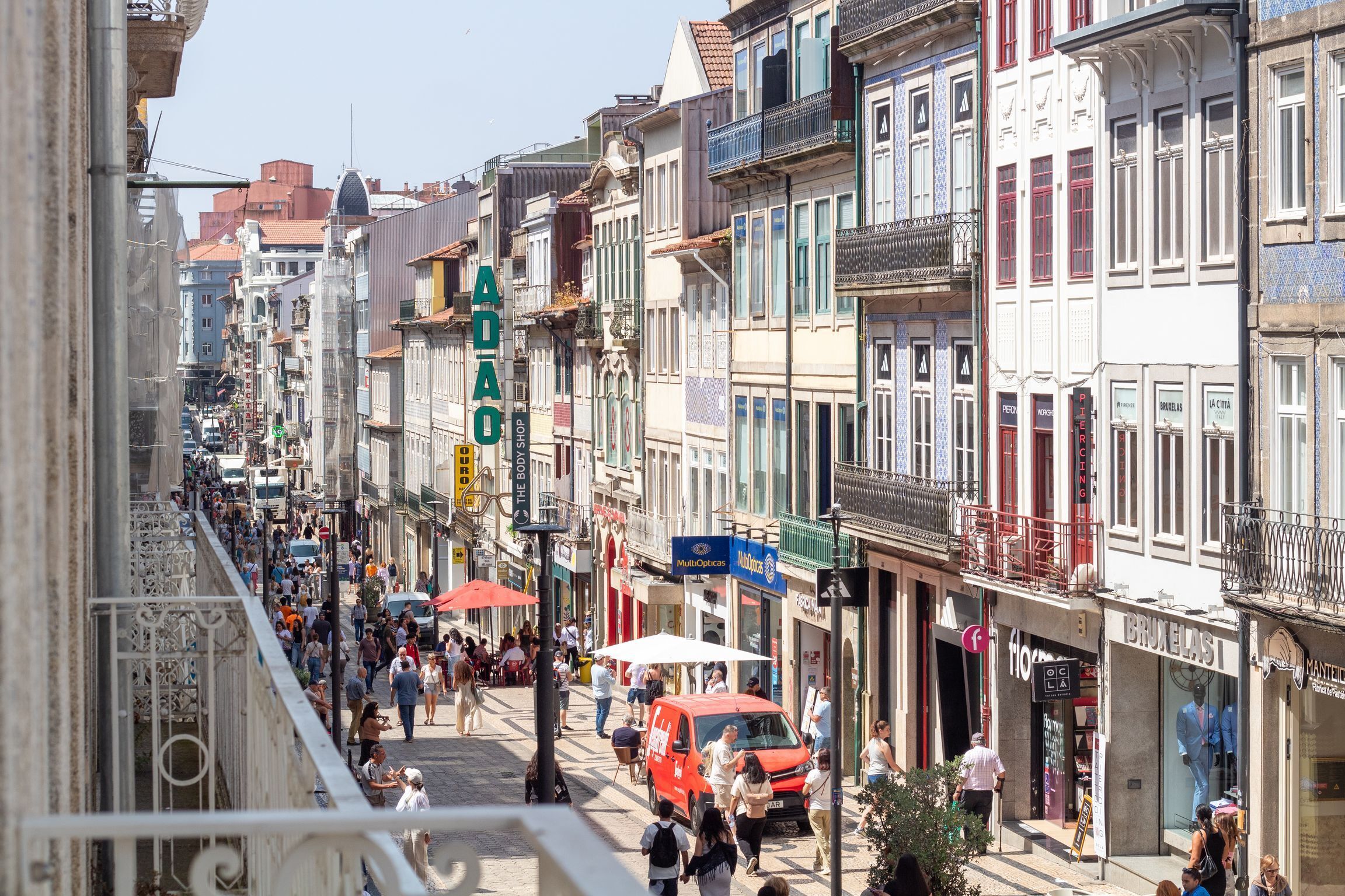 A busy street lined with colorful buildings, shops, and pedestrians.