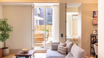 A modern living room with a sofa, a coffee table, and a potted plant.