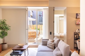 Una sala moderna con un sofá, una mesa de centro y una planta en maceta.