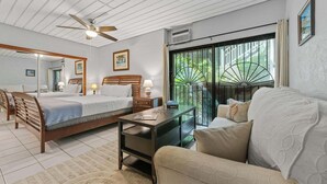 A bedroom with a bed, a desk, a chair, and a sofa. There is a window with a view of greenery. - The Caribbean Innisfree 1BR/2BA @Point Pleasant/Private Balcony/3 Pools/Beach! (Estate Smith Bay, East End Quarter)