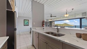 A modern kitchen with a large island, stainless steel appliances, and a view of the sea. - The Caribbean Innisfree 1BR/2BA @Point Pleasant/Private Balcony/3 Pools/Beach! (Estate Smith Bay, East End Quarter)