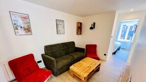 A living room with a green sofa, two red chairs, and a wooden coffee table. - High-end flat in the centre of Gérardmer (Gérardmer)