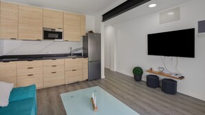 A modern kitchen with wooden cabinets, a built-in oven, and a refrigerator. - Holiday Home 'Us' with Private Terrace and Wi-Fi (Arinaga)