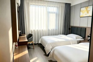 A hotel room with two beds, a desk, a chair, and a large window with curtains. - Kaixuan Hotel Shennongjia (Shennongjia)