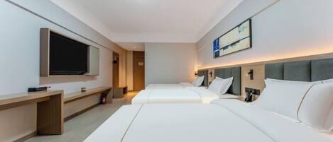 A hotel room with two beds, a TV, a desk, and a painting on the wall.