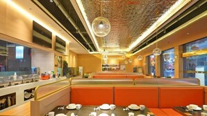 Un restaurante con cabinas y mesas, algunas con platos y cubiertos.