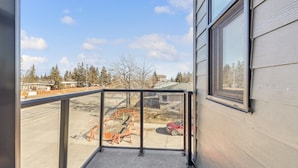 A balcony with a view of a construction site and parked cars.