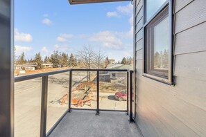 A balcony with a view of a construction site and parked cars.