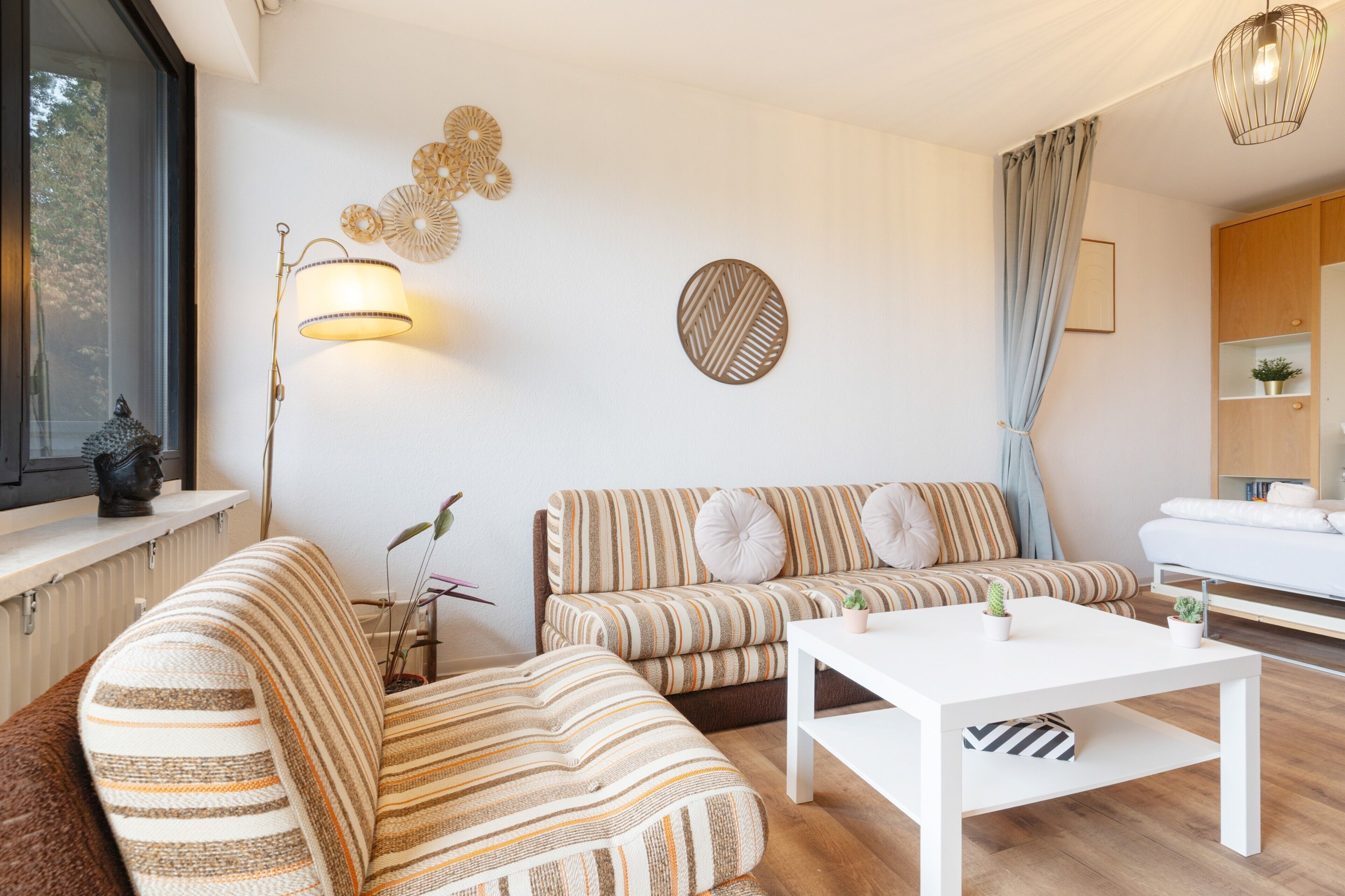 Un salon moderne avec un canapé, une table basse et une lampe.