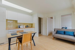 Un espacio habitable pequeño con kitchenette, comedor y sofá.