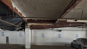 A parking garage with concrete pillars and walls, some with blue text.