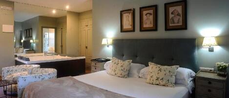 A bedroom with a large bed, a bedside table, a chair, a dresser, and a mirror.