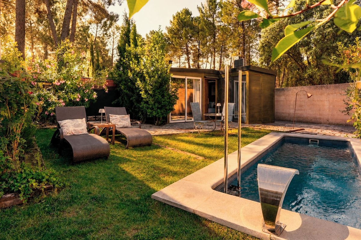 Ein Garten mit Pool, Liegestühlen und einer kleinen überdachten Sitzgelegenheit.