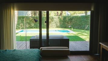 A room with a sliding glass door leading to a backyard with a pool and outdoor furniture.