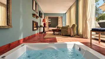 Un área de spa con un jacuzzi, una zona de estar con una mesa y sillas, y vistas al exterior.