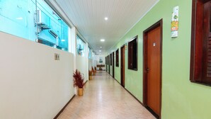 Un pasillo con puertas, piso de baldosas y una pared con señal numérica.