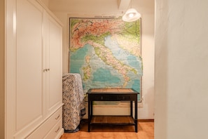 A room with a large map on the wall, a wooden table, and a patterned chair.